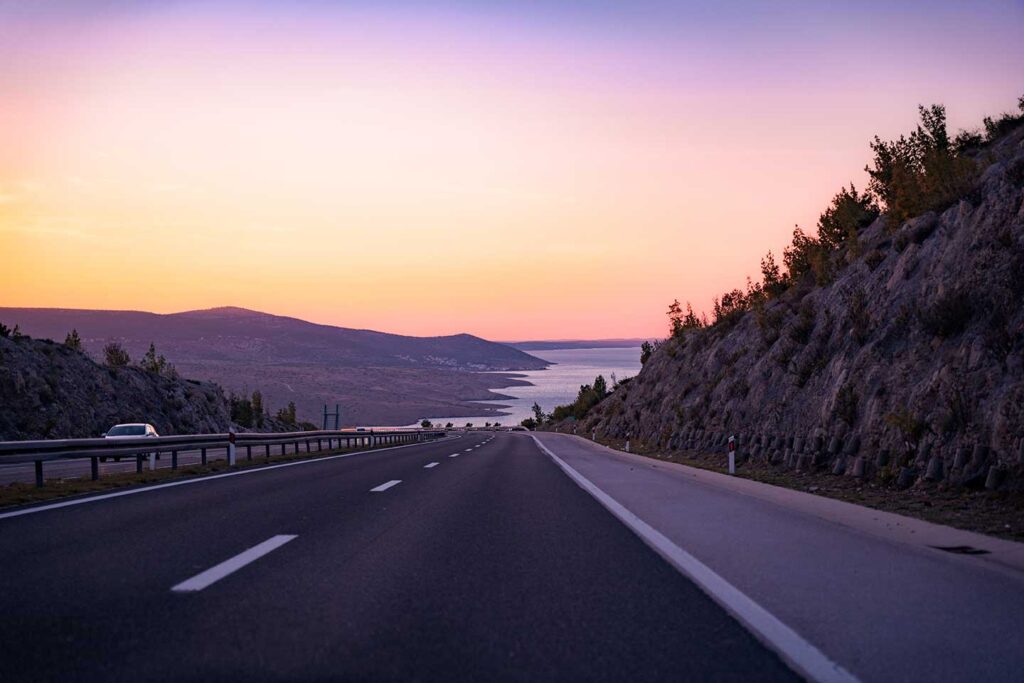 Coastal road coast, sea and mountains at dawn.